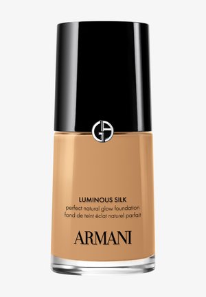 Flacon de fond de teint Armani Luminous Silk avec un bouchon noir et du fond de teint liquide beige à l'intérieur.