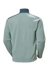 Chaqueta de forro polar verde claro con mangas largas, cuello alto y textura suave. Presenta detalles en azul oscuro en los hombros.