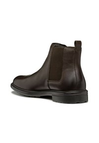 Botas Chelsea de piel marrón con paneles laterales elásticos, punta redondeada y suela de goma texturizada. Cuenta con una lengüeta para facilitar el calzado.
