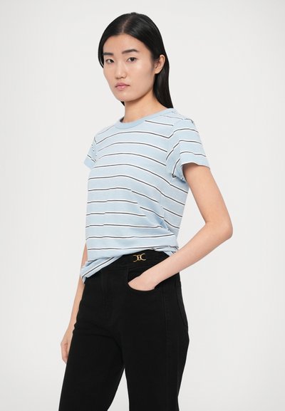 Svetlomodré pruhované tričko s krátkymi rukávmi a okrúhlym výstrihom, kombinované s čiernymi nohavicami s zlatým akcentom na páse.