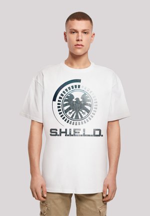Hvit bomulls t-skjorte med et stort grafisk trykk av et skjoldlogo og teksten "S.H.I.E.L.D." i mørke farger. Avslappet passform, kortermet.