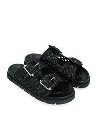Infradito nere realizzate in materiale tessuto con grandi fibbie circolari, caratterizzate da una superficie testurizzata, suole piatte e design open-toe.
