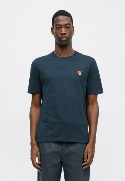 Tricou din bumbac bleumarin, cu guler rotund și mâneci scurte, având un cap de vulpe portocalie brodat pe piept.