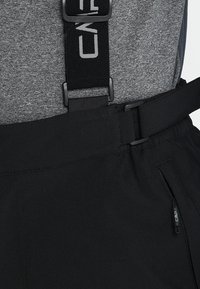 Pantalons de ski noirs avec bretelles ajustables, au design épuré, et poche zippée ; fabriqués en tissu doux et léger.