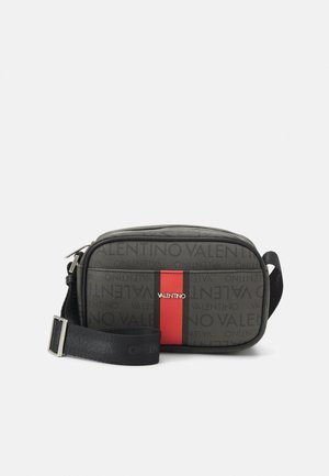 Kompakt sort Valentino crossbody-taske med justerbar rem, gentaget logomønster og central rød og sort lodret stribe.