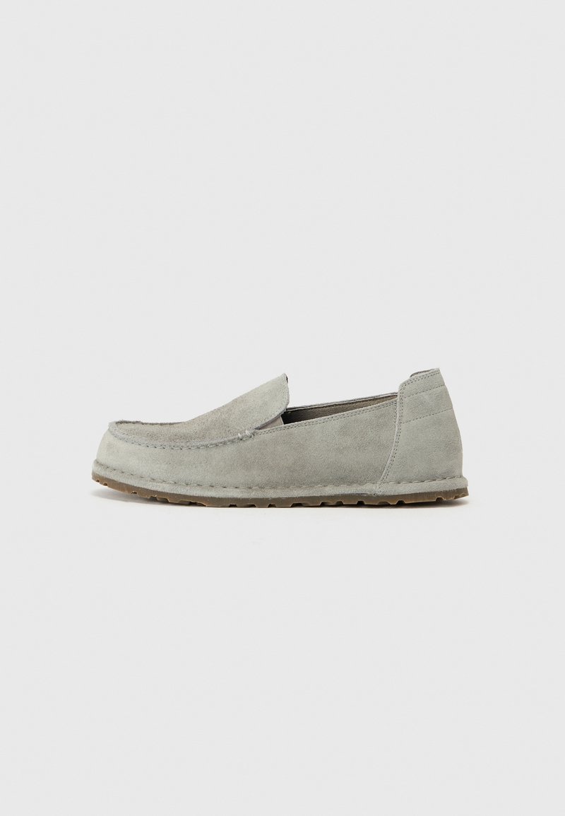 Gray suede slip-on shoes with a rounded toe, stitched detailing, and textured rubber outsole for grip. Simple and minimal design.