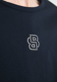 Marineblå bomull T-skjorte med rund hals og et glitrende rhinsteinlogo-design på brystet, med sammenflettede bokstaver.