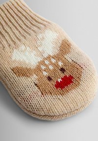 Pantofii tricotati au un gradient de culoare bej și crem, având un design cu fața unui ren în nuanțe de maro, alb și roșu, cu textură ribbată.