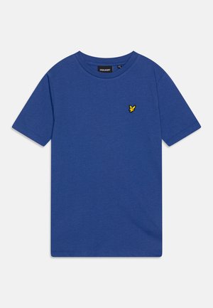 Sininen puuvillapaita, jossa on pyöreä pääntie ja lyhyet hihat. Vasemmassa rinnassa on pieni keltainen brodeerattu logo. Paita on sileäpintainen.
