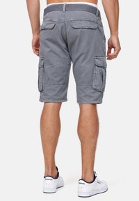 Grå cargo shorts med en afslappet pasform, flere lommer og en bæltestrop i taljen. Materialet har et blødt, tekstureret udseende.