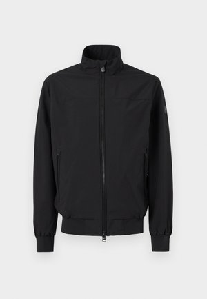 Juoda striukė su užtrauktuku, stovinčiu apykakle, elastingomis rankogalių dalimis ir užtrauktukais šoninėse kišenėse, rodoma ant baltos fono.