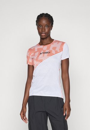 T-shirt à manches courtes blanc avec des rayures diagonales orange et un motif texturé. Affiche le logo "TERREX" en noir sur la poitrine.