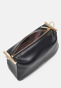 Schwarze Lederpouch mit einem goldenen Metallreißverschluss, ausgestattet mit einem geometrischen Muster im Inneren und einem flachen Boden für Stabilität.