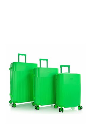 Tres maletas rígidas de color verde brillante de diferentes tamaños con asas extensibles y cuatro ruedas sobre un fondo blanco.