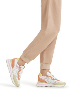 Sneaker multicolori con una tomaia bianca e accenti arancioni, gialli e lilla chiaro, realizzate in morbido suede e con suola testurizzata.