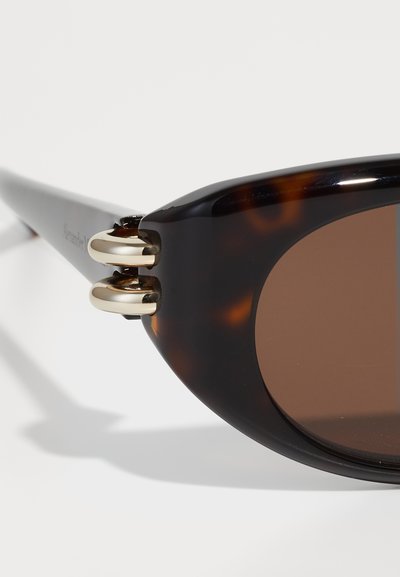Occhiali da sole tartarugati con lenti marroni. Presentano dettagli in metallo dorato e una finitura lucida. Design elegante con una silhouette moderna.
