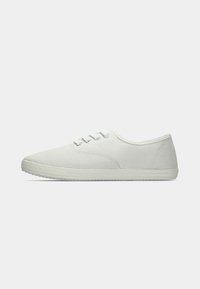 Hvide kanvas sneakers med lavt design, gummisål, snørebåndslukning og glat tekstur. Enkel, minimalistisk stil.