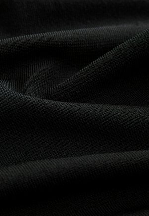 Svart stickat tyg med en mjuk, lätt räfflad textur, med subtila variationer i nyans och djup.