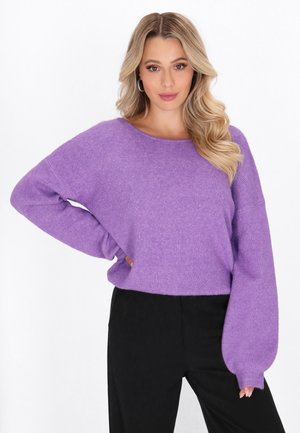 Lila gestrickter Pullover mit lockerem Schnitt, gerippter Textur, weiten Ärmeln und rundem Ausschnitt, kombiniert mit schwarzen strukturierten Hosen.