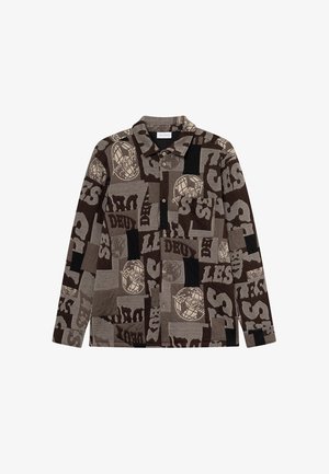 Hnědá košile s vzory, která obsahuje různé textury a designy, s velkými textovými prvky a límečkem. Dlouhé rukávy, zapínání na knoflíky.