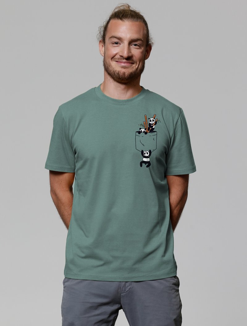 Grafisches T-Shirt in gedämpftem Grün mit einer Taschenoptik und cartoonhaften Pandas. Kurze Ärmel und runder Halsausschnitt. Weicher Stoff.