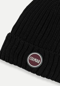 Zwarte gebreide beanie met ribbelstructuur, voorzien van een ronde bordeauxrode en zilveren merkpatch met de tekst "COLMAR" aan de voorkant.
