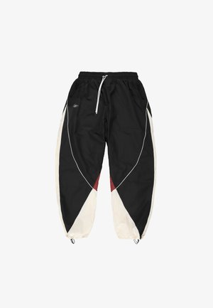 Czarne spodnie dresowe z białymi i czerwonymi geometrycznymi panelami, elastycznym pasem z białym sznurkiem, zamykanymi na zamek kieszeniami bocznymi oraz elastycznymi ściągaczami z regulacją.