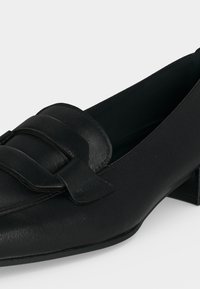 Mocassin en cuir noir à petit talon avec bride et boucle sur la tige, bout arrondi et talon bloc.