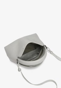 Gray leather handbag with a soft, structured design; features a flap closure, adjustable strap, and lined interior with a zip pocket.