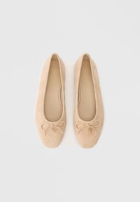 Μπεζ suede μπαλετόπλακες με στρογγυλή μύτη, διακοσμητική κορδέλα και ένα μικρό γούστο στο κέντρο της κορδέλας. Μαλακή, λεία υφή.