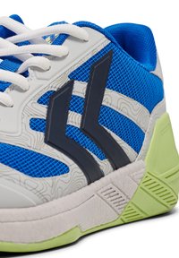 Aktive Sneakers mit einem blauen Mesh-Obermaterial, strukturierten grauen Paneelen, schwarzen Akzenten, weißen Schnürsenkeln und einer grünen Gummisohle mit gemusterten Details.