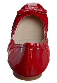 Ballet flat en cuir verni rouge avec un bout arrondi, présentant un petit nœud à l'avant et une doublure intérieure beige.