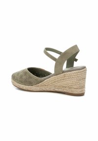 Sandali wedge verdi con motivo floreale ritagliato, piattaforma espadrille testurizzata e cinturini alla caviglia incrociati. Materiale morbido e punta arrotondata.