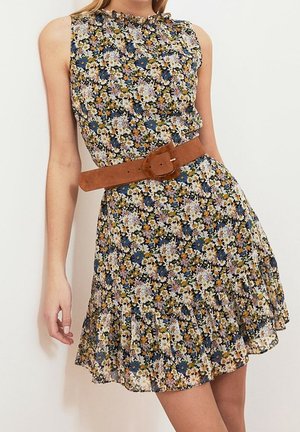 Sleeveless floral dress with ruffled hem, featuring small white, blue, and yellow flowers, cinched at the waist with a wide brown belt.