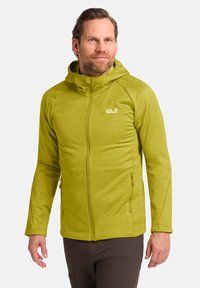 Olijfgroene zip-up jas met capuchon, gemaakt van een textiel met een zachte, gestructureerde stof; heeft zijzakken en een klein logo op de borst.