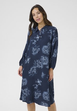 Rochie florală de culoare albastru marin cu guler, detalii cu nasturi, mâneci lungi și croială lejeră, având motive florale de culoare albastru deschis.
