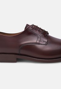 Braune Lederformalschuhe mit glatter Oberfläche, runder Zehenpartie, sechs Ösen und einem dezenten Stichdetail in der Nähe der Schnürsenkel.