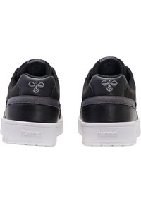 Czarne trampki wykonane ze skóry i siateczki, z białą gumową podeszwą, teksturowanymi akcentami oraz logo na pięcie i języku.