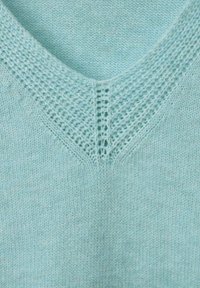 Hellblau gestrickter Pullover mit V-Ausschnitt, der ein strukturiertes Spitzenmuster am Kragen aufweist, aus weichem, atmungsaktivem Stoff gefertigt.