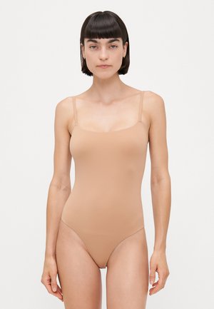 Maillot de bain une pièce nude avec des bretelles fines réglables, un décolleté en scoop et des jambes échancrées. Fabriqué en tissu lisse et extensible.