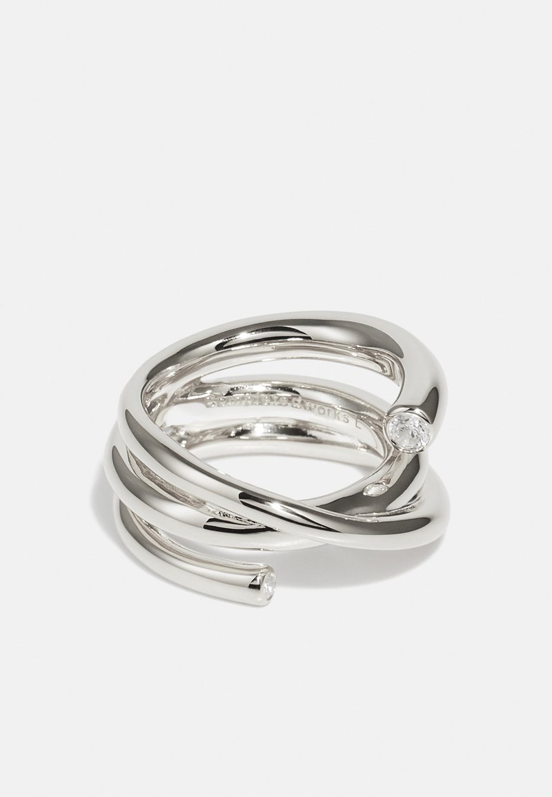 Δαχτυλίδι σε ασημένια απόχρωση με σχεδιασμό που συστρέφεται και ομαλές, ανακλαστικές επιφάνειες, συμπληρωμένο με μια μικρή διαφανή πέτρα.