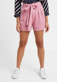 Różowe szorty z wysokim stanem, plisami i wiązanym paskiem z przodu. Wykonane z lekkiego materiału, charakteryzują się gładką fakturą i dopasowanym krojem.