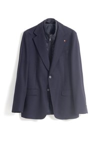 Blazer navy con tejido texturizado, solapas de pico, dos bolsillos delanteros y un forro interno con cremallera. Presenta botones de acento marrón.