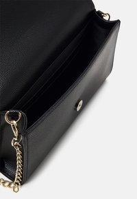 Borsa a tracolla nera in pelle con una texture a ciottoli, hardware dorato e chiusura a scatto magnetica. L'interno presenta più scomparti.