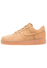 Nike Air Force 1 juoksukengät ruskeassa nahassa. Varusteena ovat rei'itetyt varpaat, nauhakiinnitys edessä ja yhteensopiva kumipohja, jossa on "AIR"-yksityiskohta.
