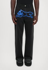 Sorte jeans med et blåt tegneserie-kat design på låret. Har en lige ben-snit, klassisk fem-lomme stil og metalknap-lukning.