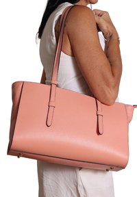 Borsa a tote in pelle rosa con doppie spalline, forma rettangolare, superficie testurizzata e bordo a contrasto. Presenta hardware dorato alla base.