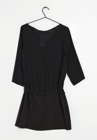 Svart klänning med trekvartsärmar, elastisk midja, rynkad textur vid midjan och en lös passform. Slät tyg, minimalistisk design.