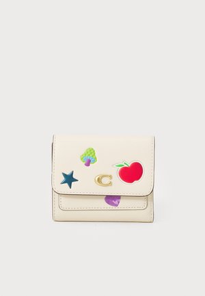 Portafoglio in pelle color beige chiaro con adesivi colorati: mela rossa, cuore viola, fungo verde, stella blu e dettaglio del logo in oro sulla patta.