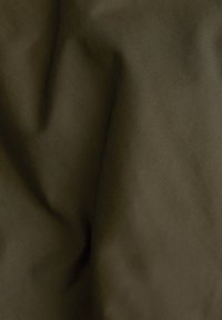 Tissu lisse vert olive foncé avec des plis subtils et un léger éclat.